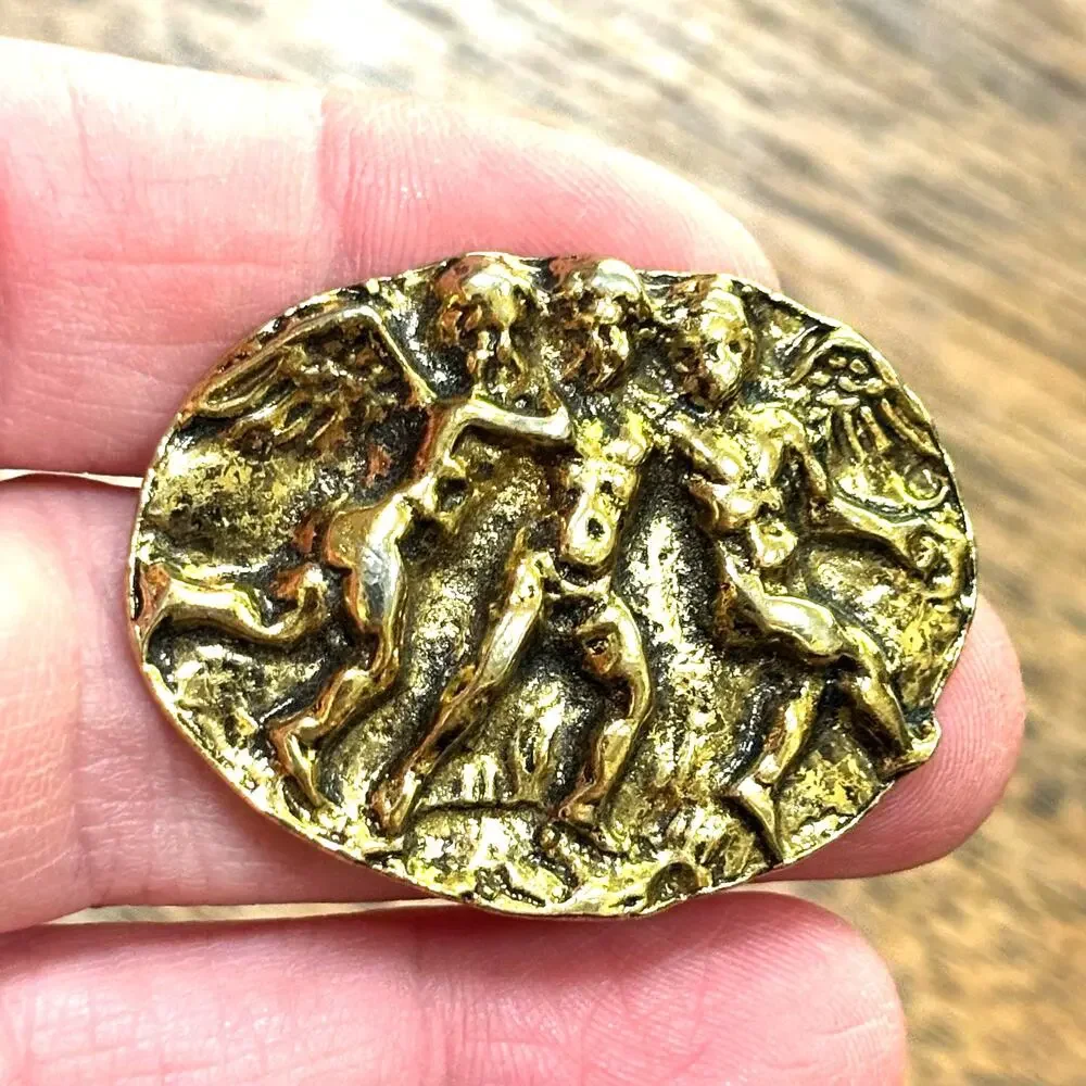 Vintage gold tone metal brooch relief repousse style oval dancing winged cupids